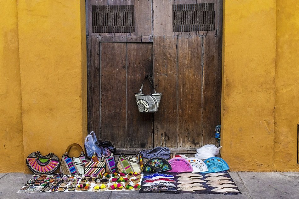 selling colored wallets on the floor near the doors