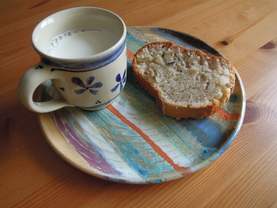 a mug of milk and a piece of loaf for a late breakfast