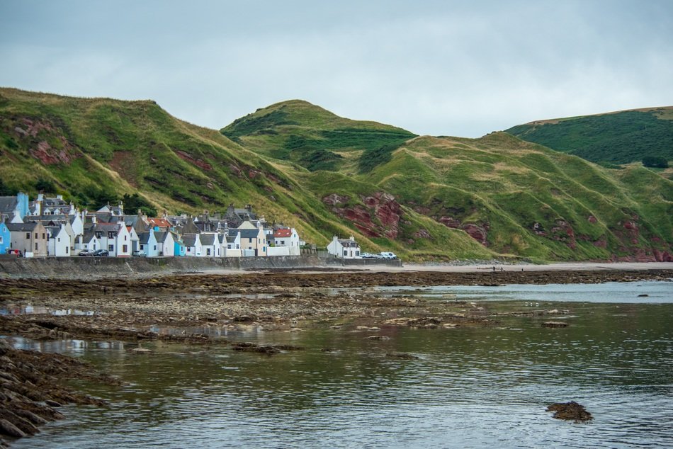 colourful houses on green mountain at water