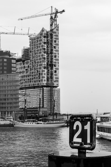 black and white photo of a construction crane near the river
