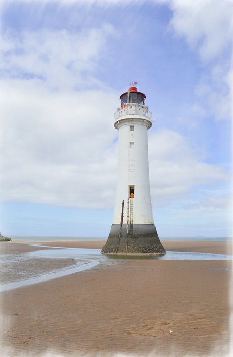 lighthouse with white walls near the ocean