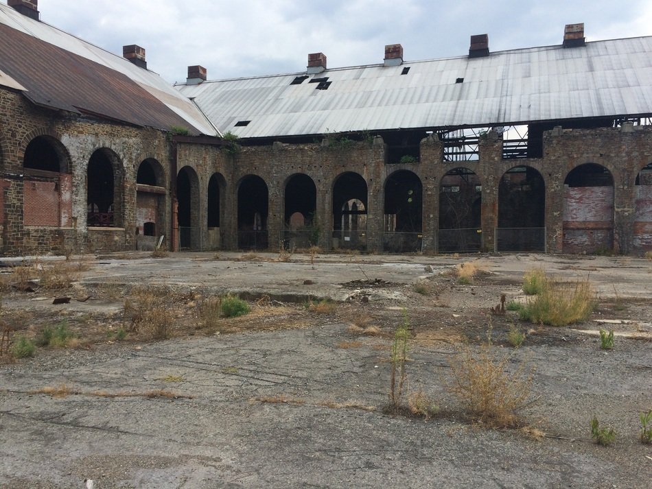 abandoned courtyard in front of the ruins of an old factory