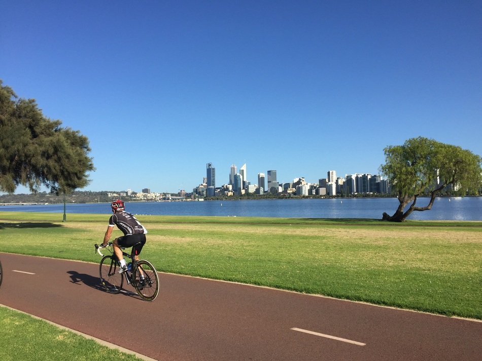 cyclist on the asphalt road on the city embankment