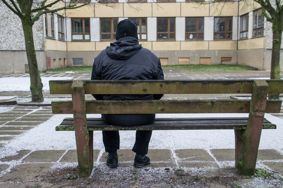 man on a wooden bench near the building