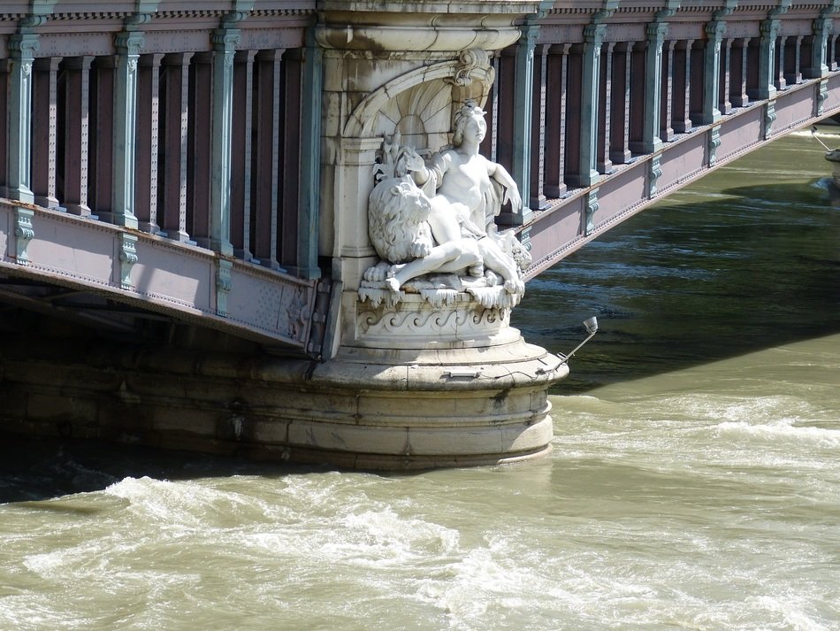 statue near the bridge on the river
