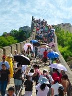 Tourists with umbrellas walking on Great Wall Of China