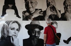 man looking at photos on wall, uk, england, London