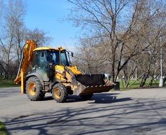 Yellow black excavator on the road