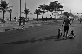 father with two kids walking on street, brazil