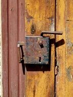 closed rusty lock on a wooden door