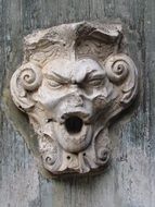 angry gargoyle sculpture on the wall