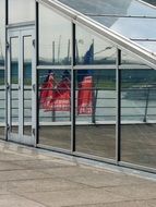 glass facade with a reflection of the flags