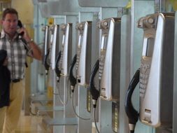 stationary street phones in row and man talking