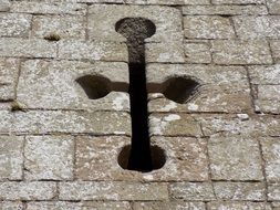 cross on the stone facade of a medieval building