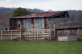 landscape of Old fenced Farm Building in countryside at autumn