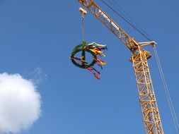 green wreath with colorful ribbons on tower crane at sky, Customary Topping Out Ceremony