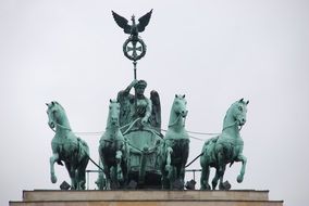 Quadriga of Victory, sculpture at top of brandenburg gate at clouds, Germany, Berlin