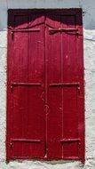 Window with closed Wooden Red shutters on grey wall, greece, cyprus, kato lefkara