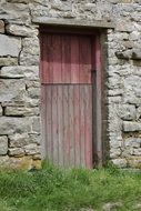 Red wooden door in old Stone wall