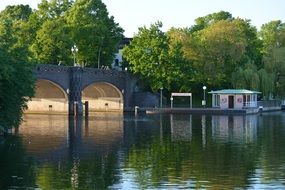 stone bridge over the river among green trees