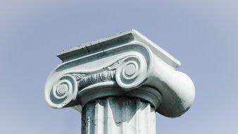top of the beautiful ornamental greek column at blue sky background