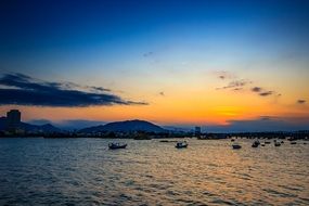 distant view from the sea to the city on the coast at sunset