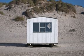 white hut on a sandy beach