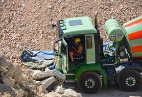 girl sits in cabin of concrete mixer Vehicle on construction site, Lunch Break