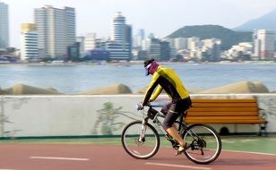 young man Cycling on embankment in city