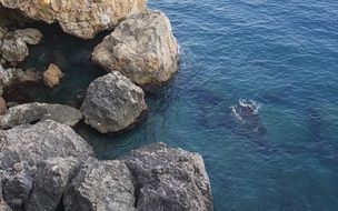 people swimming in blue sea at rocks, Turkey, Antalya