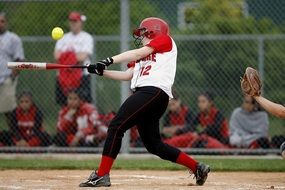 player hits the ball in a softball