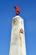 Hammer And Sickle beneath red star, soviet symbols on Monument