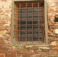 metal grate on window in medieval stone wall