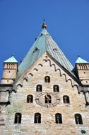 top part of old sand stone Clock Tower at blue sky, germany