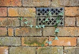 old ventilation grille on a brick wall