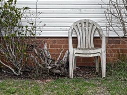 two dirty garden chairs near the wall