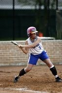 a woman in a helmet batting a bat