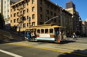 people on side of vintage tram in city with lights and shadows, Usa, california, San Francisco