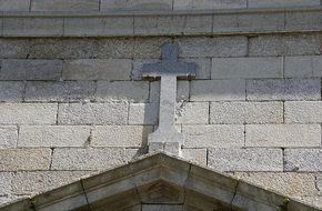stone cross on a building wall