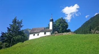 church on a green hill in the Alps