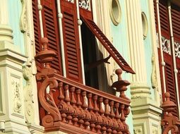 red shutters on Window with balcony, old house Facade