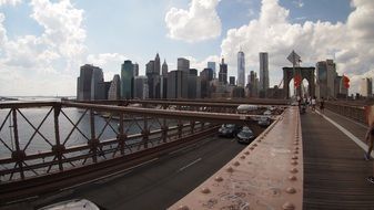 cars drive along brooklyn bridge to new york