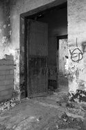 black and white photo of an entrance door to an abandoned building