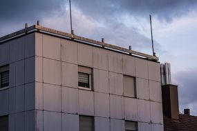 concrete building with antennas under a cloudy sky