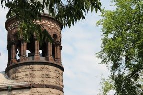 old stone church tower among the trees