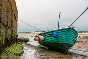 green wooden boat on the shore
