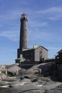 distant view of the lighthouse among the stones on a sunny day