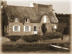 black and white photo of the rural building by the river