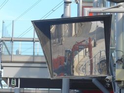 Construction machinery reflection on big mirror