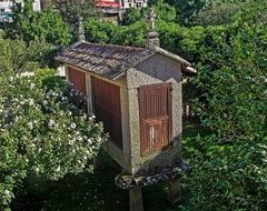Galician Barn, stone pillar building with cross on tiled roof, spain, galicia